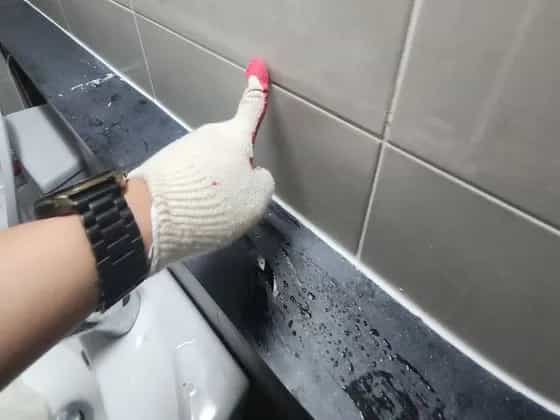 욕실 타일 이음새를 마감하는 모습